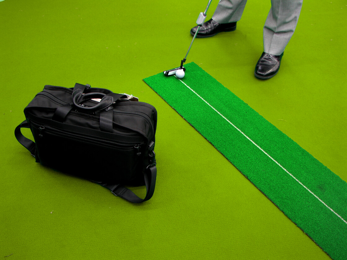 a salaryman trying a golf club in a shop in Yurakucho